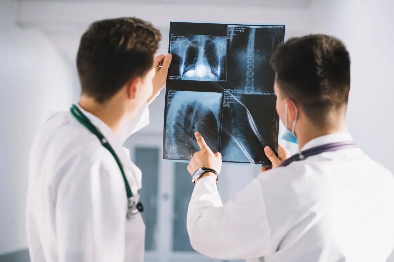 Dos médicos observan una radiografía. Foto provisional de banco de imágenes.